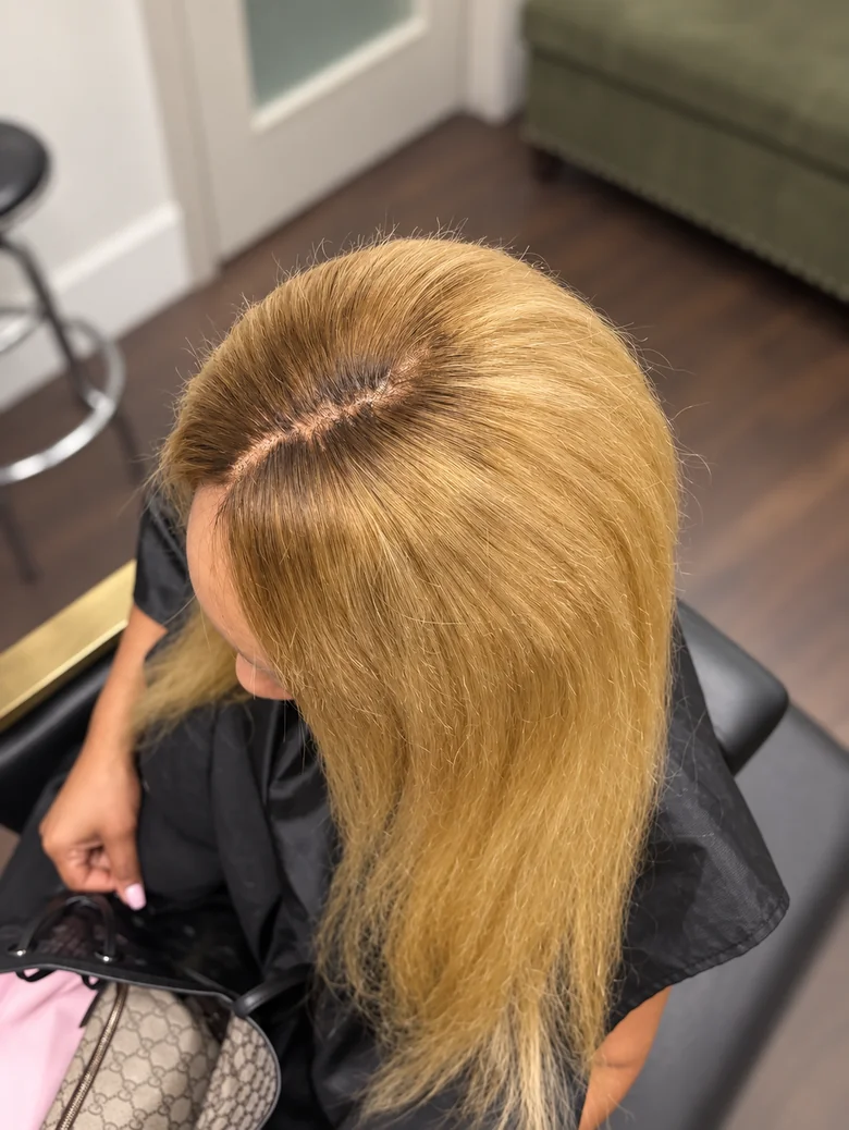 Honey blonde sew-in with a clean side part