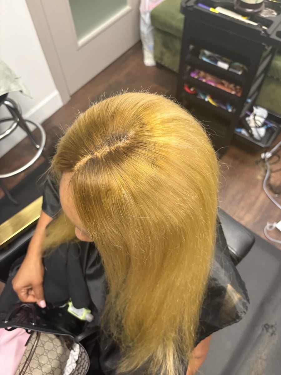 Honey blonde sew-in with a clean side part